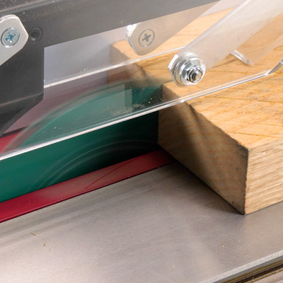 a grizzly pro blade running on a table saw, which is cutting through a board
